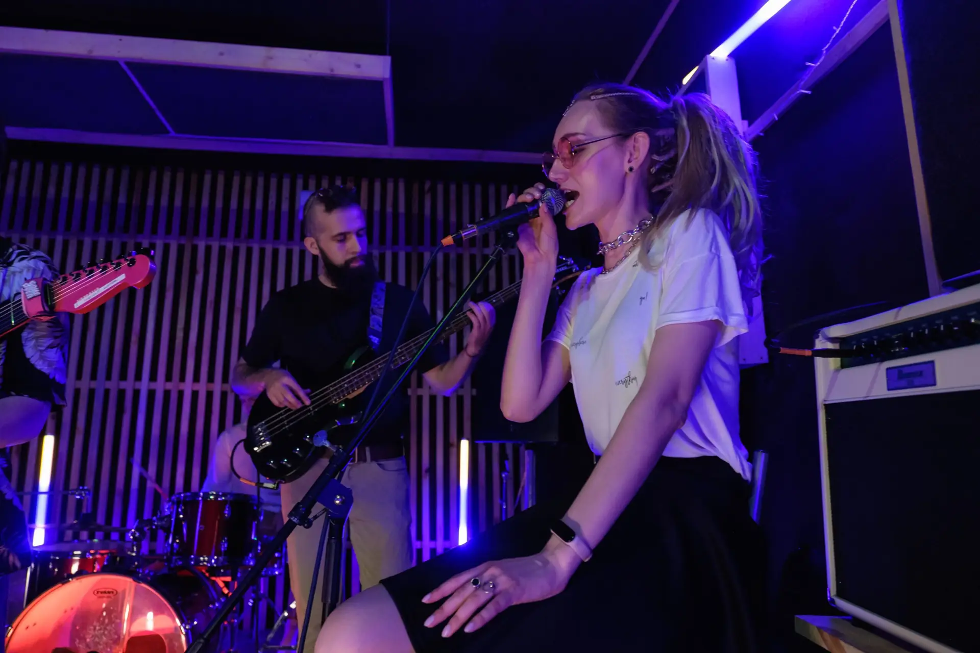 Dynamic live performance of a band with vibrant lighting and engaging musicians.